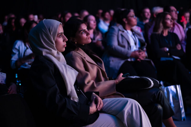 Corporate event audience members listen to a presentation at the Excel Centre.